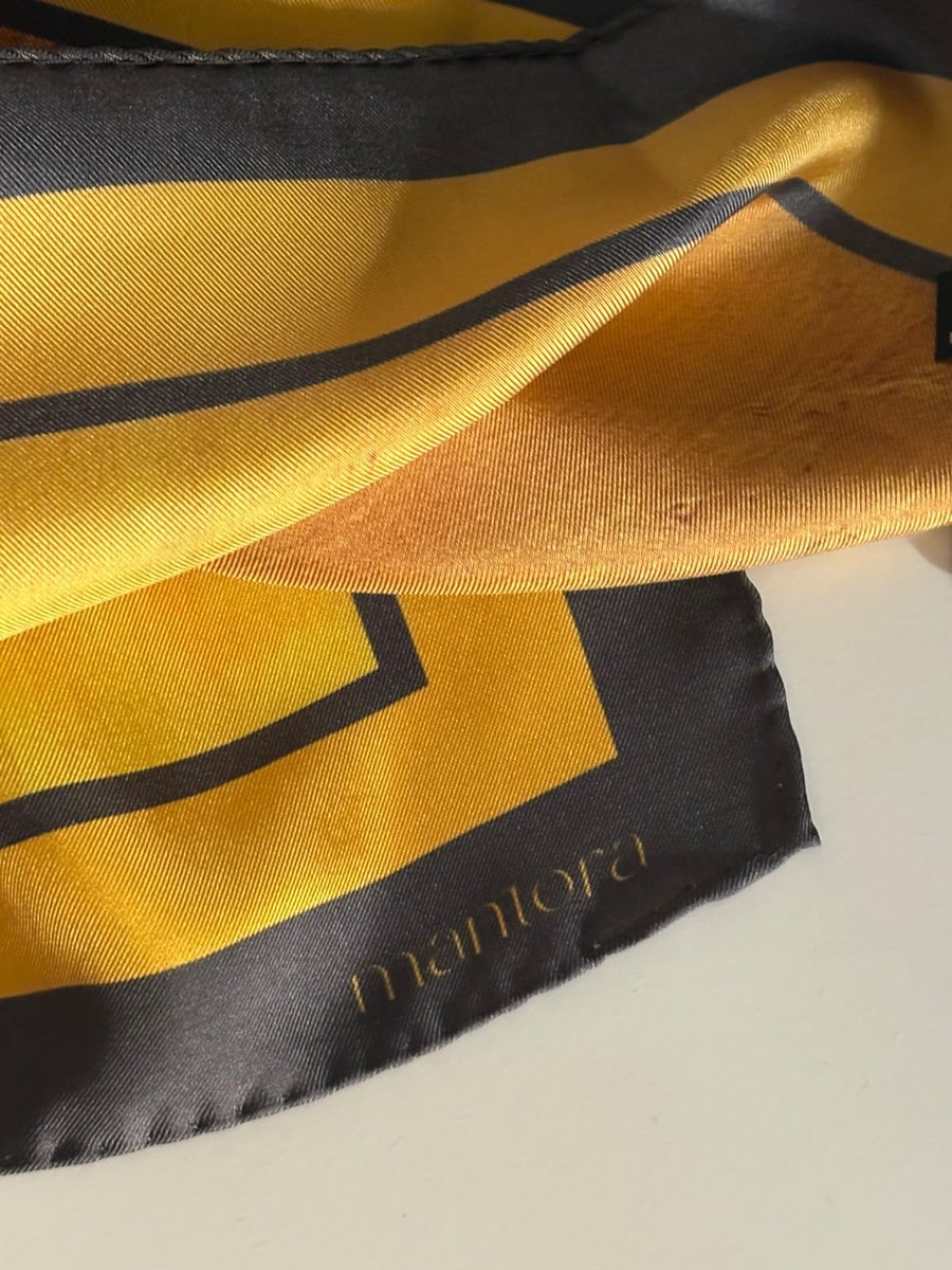 Yellow silk scarf detail with Mantora label