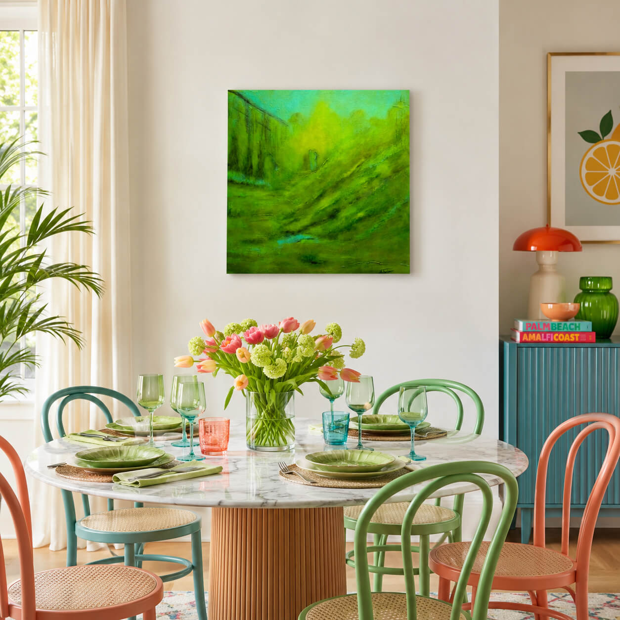 A square abstract painting with vibrant green and yellow brushstrokes hangs on a white wall above a round dining table set with colorful chairs and a floral centerpiece in a bright, modern dining room.
