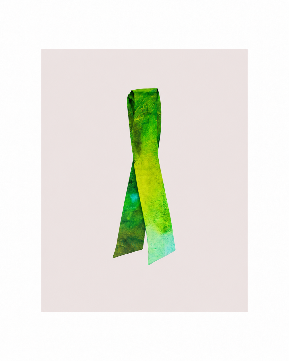A green and yellow tie-dye silk scarf tied in a loop, displayed against a pale pink rectangular background with a white border.