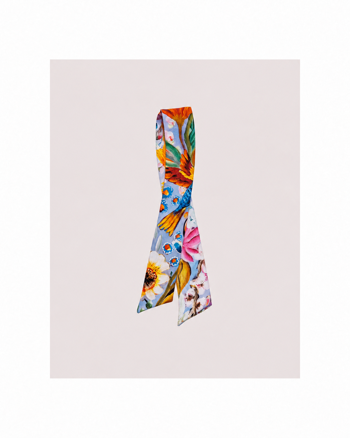 A colorful silk scarf with a vibrant floral and butterfly pattern, displayed on a light beige background.